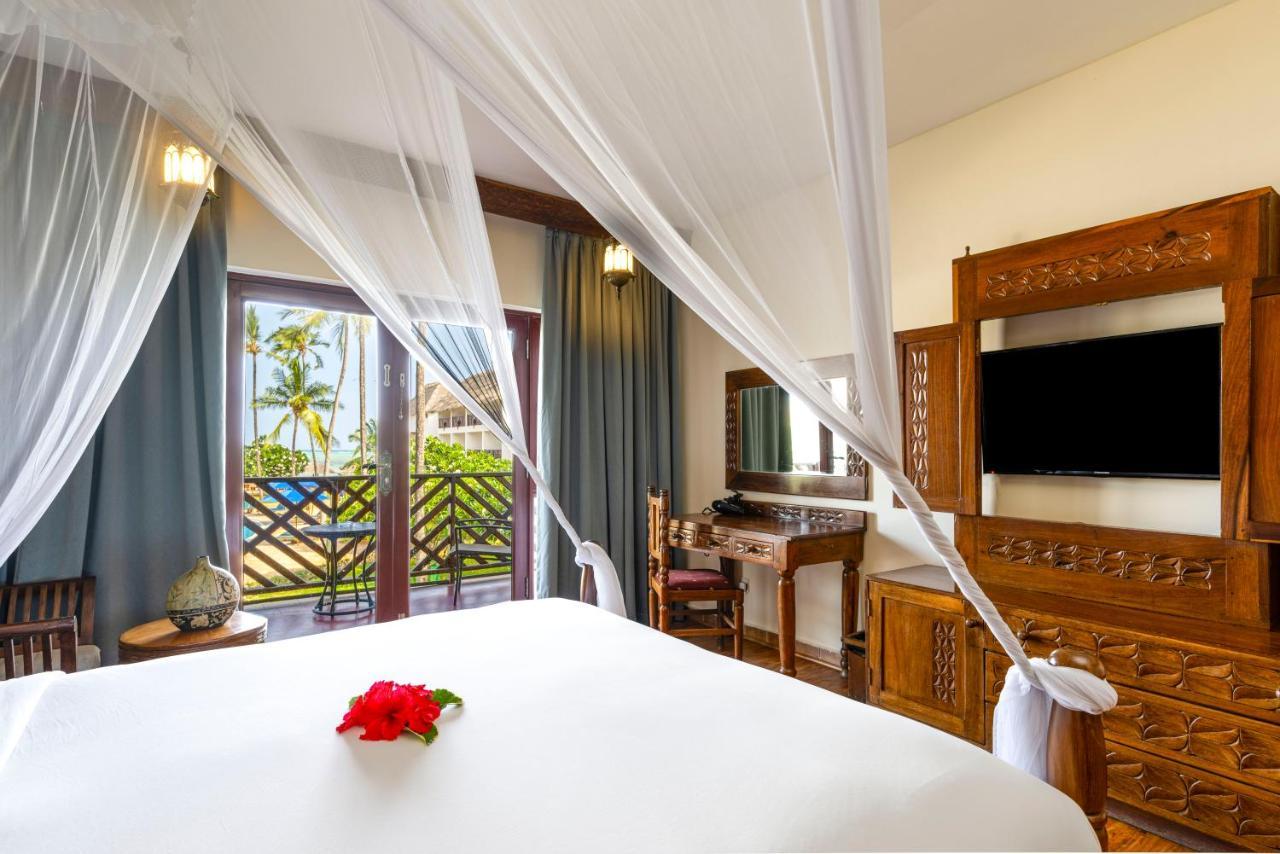 Habitación con cama grande y vistas parciales al mar