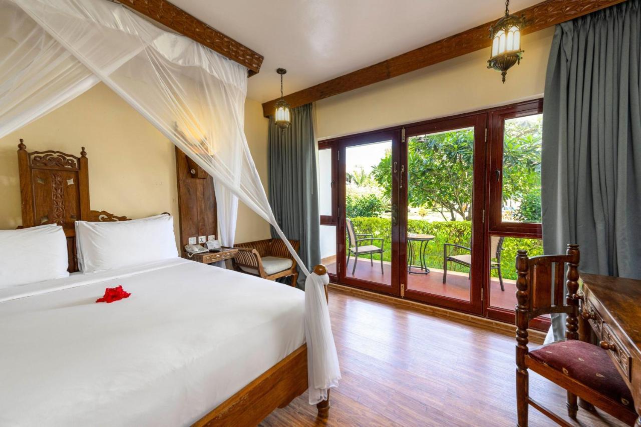 Habitación con cama grande y vistas al jardín