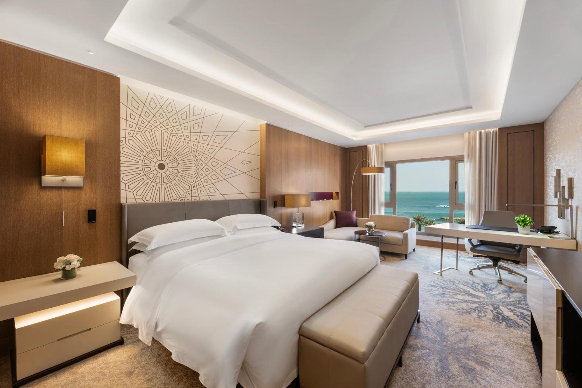 Quarto clássico com cama king-size, vista do mar e acesso à Área VIP